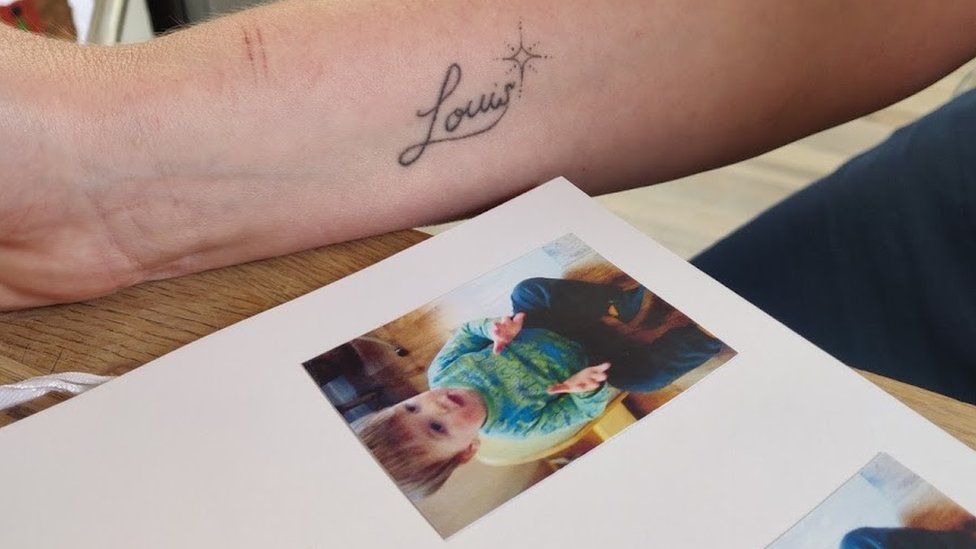 Picture of Louis and a tattoo of his name on the underside of his mother's arm