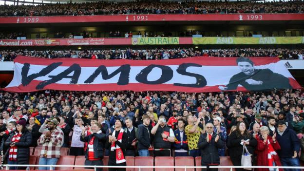 Fans hold aloft a banner with Mikel Arteta's picture and the word Vamos at the Emirates Stadium
