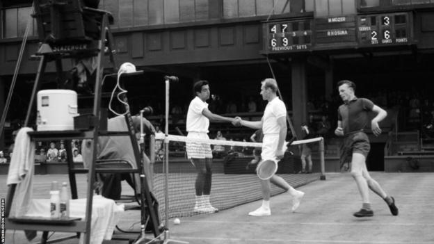 Sam Hill runs round the net as players shake hands on a Wimbledon show court in the early 1960s