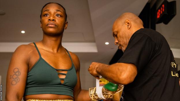 Claressa Shields has her glove laced up as she stares into the middle distance