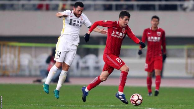 Sealy, in white, pursues Oscar in a match against Shanghai SIPG in March 2017