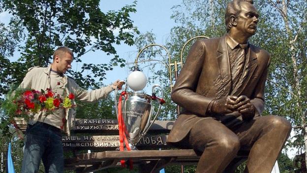 Andriy Shevchenko fulfils his promise and places the European Cup on a bench next to a statue of Valeriy Lobanovskyi