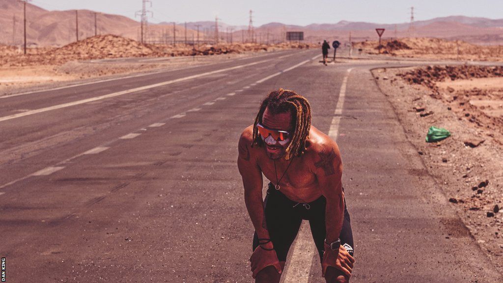 Roberto Mandje stops and catches his breath on a roadside in the Atacama Desert