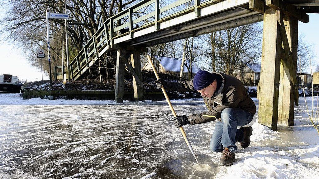 A volunteer measures the ice in 2012 when hopes were raised and then dashed that the race might be staged once again