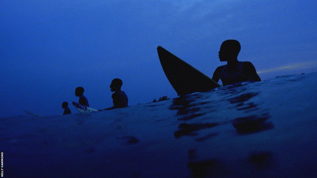A group of surfers wait for a wave off the coast of Busua in Ghana