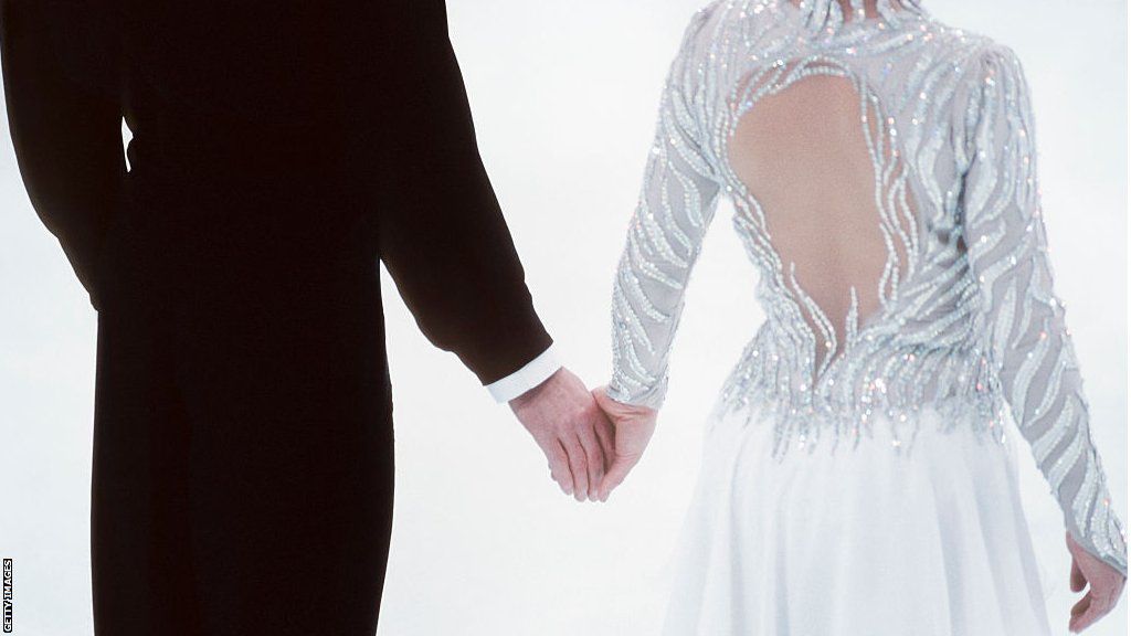 A picture showing Jayne Torvill and Christopher Dean holding hands with their backs to the camera