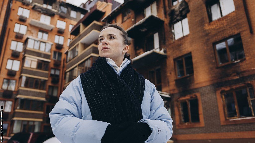 Elina Svitolina stands in front of a damaged block of flats on trip to Ukraine